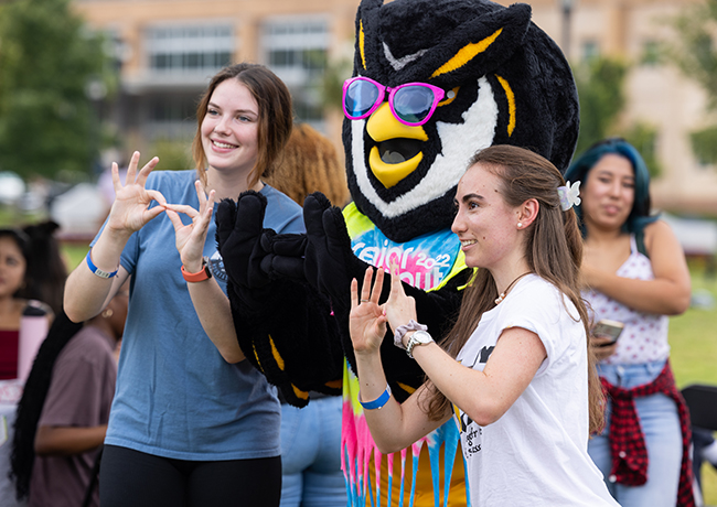 KSU student taking a picture with Scrappy for Welcome Back event.