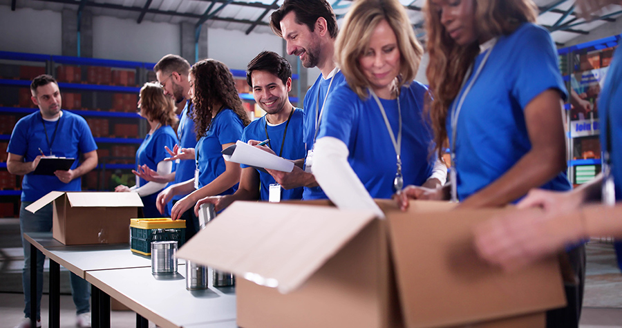 a group of people working together to package food items into large boxes