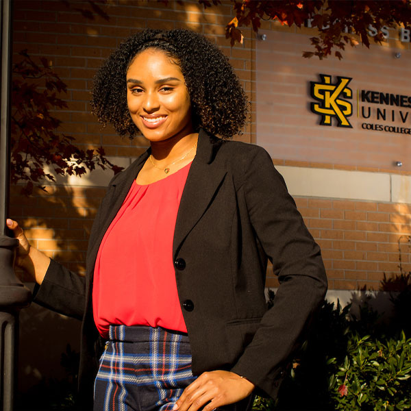 KSU alumni standing in front of business school