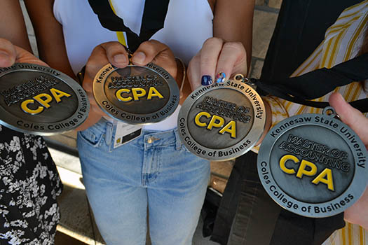 Close up of students displaying medals for completing the CPA exam