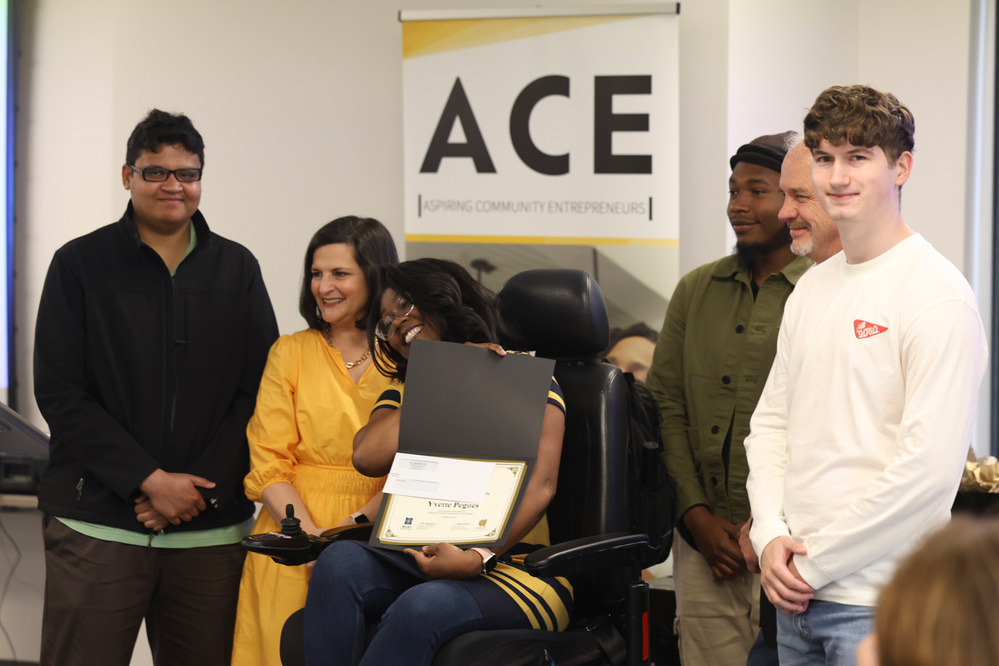 An ACE participant smiles with her new certificate of completion, alongside Coles College dean Robin Cheramie and KSU students assisting the ACE Program