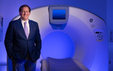 Will Chilvers stands next to a MRI machine.