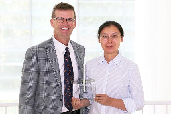  / Photo of Mark Anderson (left) and Distinguished Mentoring Award recipient, Sherry Ni, Ph.D., (right) Interim Chair of the Department of Statistics and Analytical Sciences and Professor of Statistics (STAT)