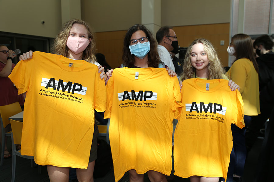  / Students holding up their new Advanced Majors Program (AMP) T-shirts at the Backstage Pass event