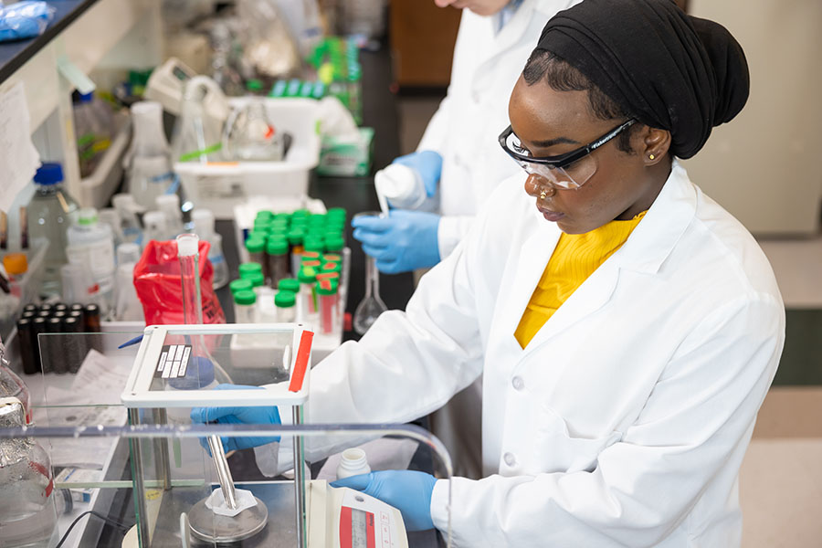 Student working on research in a lab / Two students working on biology research in a laboratory.