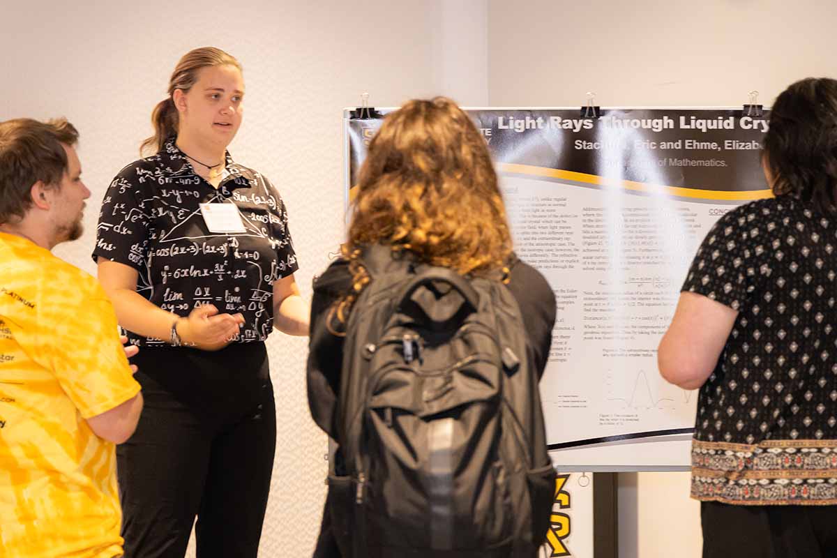 Math student presenting a research poster presentation at the Birla Carbon Symposium. / Math student presenting a research poster presentation at the Birla Carbon Symposium.