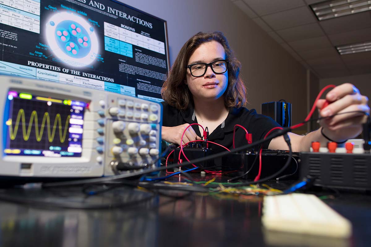 Physics student working on research with equipment. / Physics student working on research with equipment.
