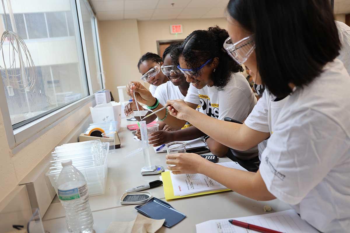 CSM PRESS program students collaborating in a science lab, engaged in a chemistry experiment. / CSM PRESS program students collaborating in a science lab, engaged in a chemistry experiment.