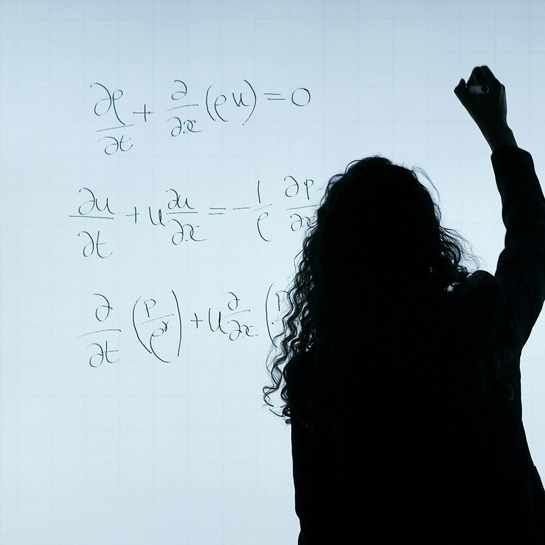 female teacher doing physic equation on white board