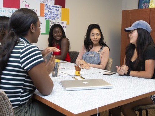 group of ethnically diverse group female students sitting together at a table