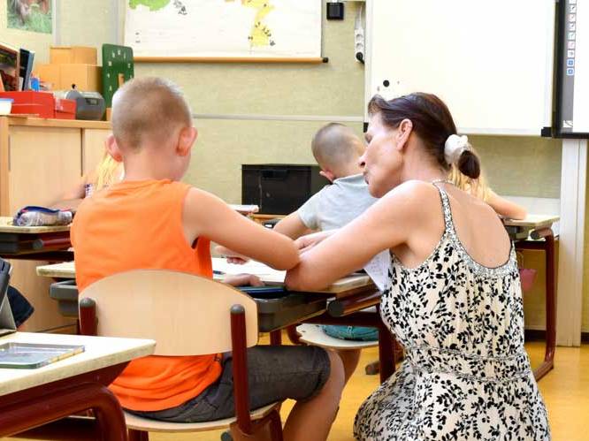 Teacher is helping a young child with school work