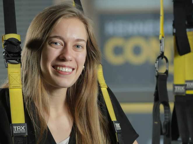 Woman strapped into safety gear smiling for picture