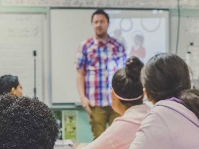 Teacher standing upfront teaching students