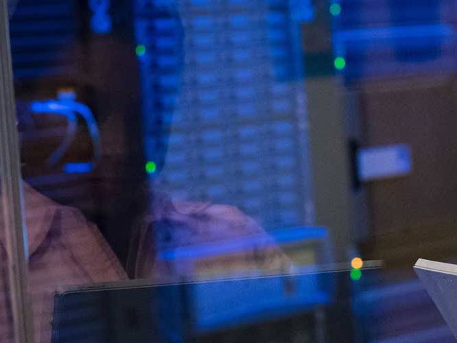 Reflection of woman looking at computer hardrive systems