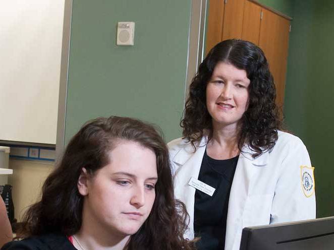 Teacher watching student focus on the computer