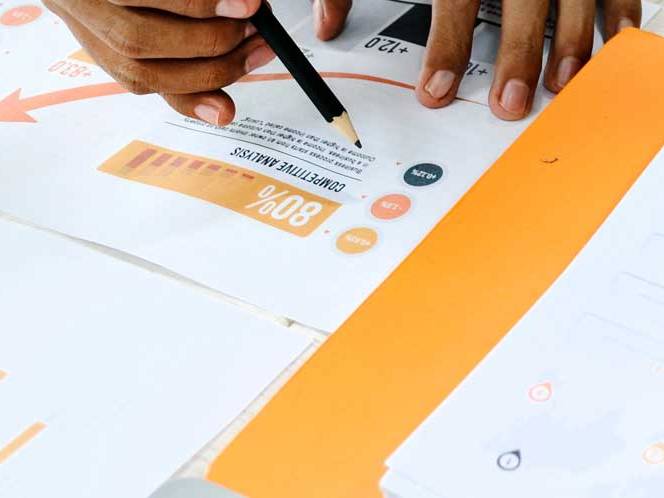 Student hovering over information and graphs with pencil