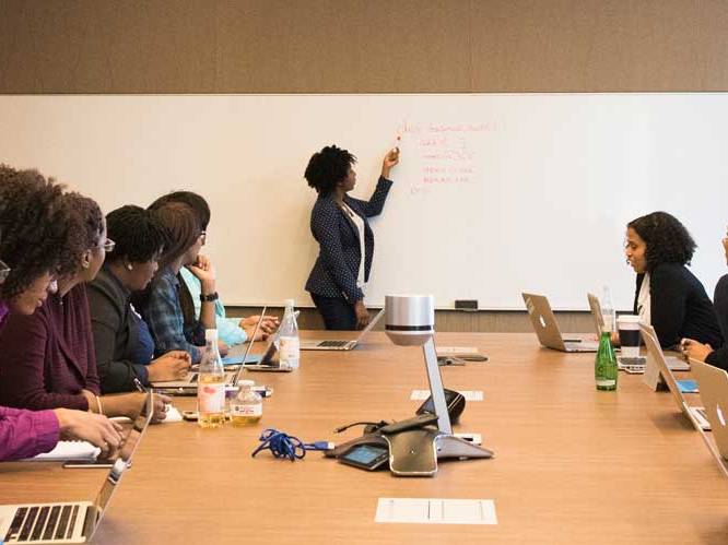 Teacher pointing to board teaching a group of students