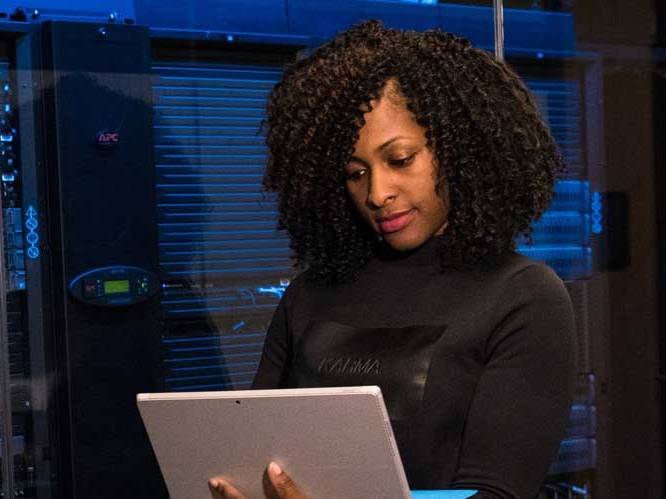 ksu student looking down at laptop in front of computer systems