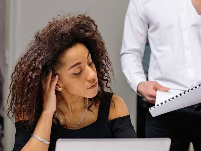 Business woman looking down at laptop focusing