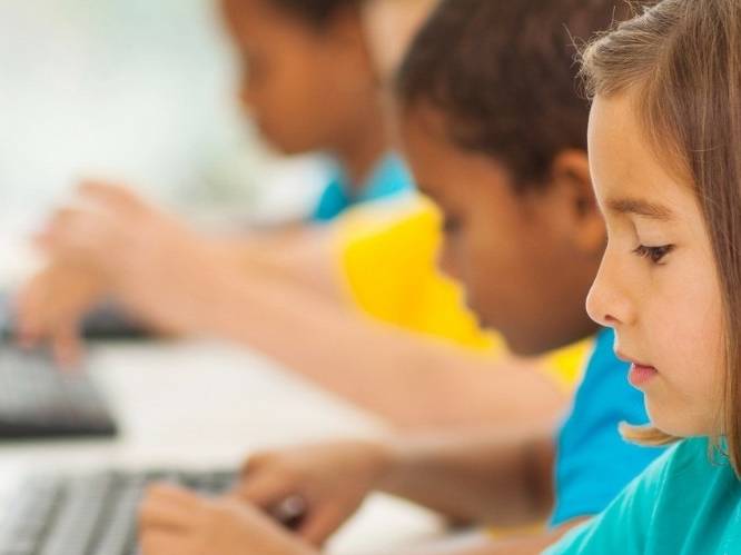 Group of young children typing on a keyboard