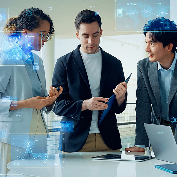 A diverse group of four professionals collaborates in an office, surrounded by digital data overlays. They appear engaged and focused, conveying teamwork and innovation.