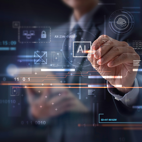 man in suit pointing with stylus at computer screen to the letters AI