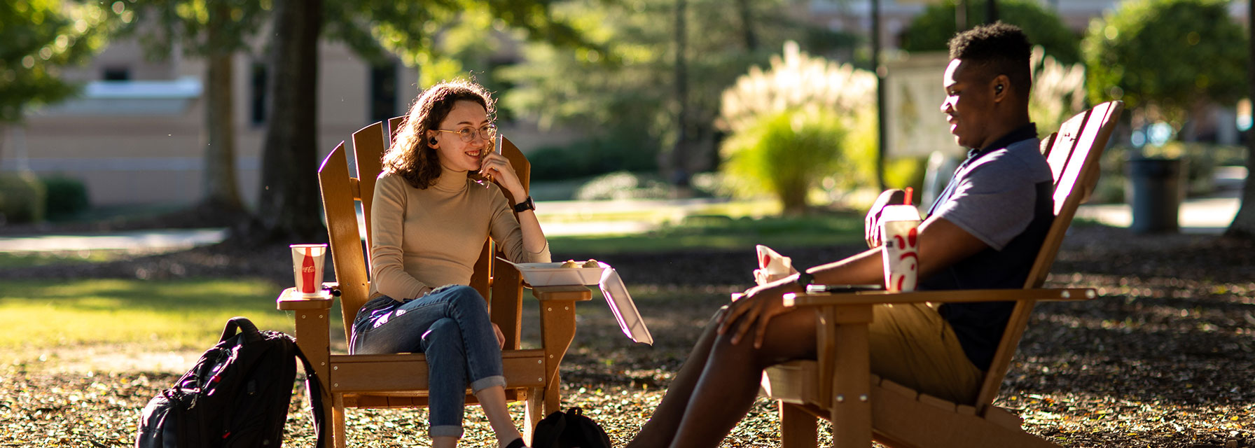 Students eating a meal from on-campus restaurants outside