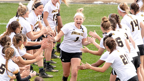KSU Lacrosse team player being congratulated by the team after scoring the winning goal at KSU's Fifth Third Stadium.