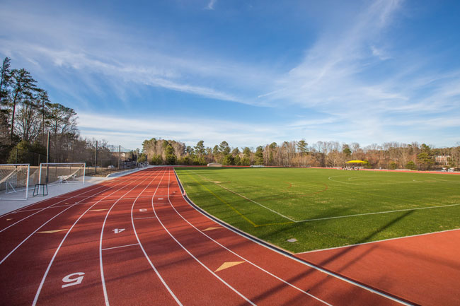 A photo of KSU Track with an aerial view of a large outdoor sports complex surrounded by trees and greenery. 
