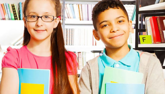 Two smiling children with books highlight KSU's commitment to literacy and the safety of minors in hosted programs.