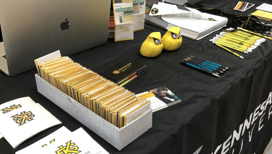 Close-up view of a KSU Event table set up, featuring a black tablecloth with the Kennesaw State University logo.