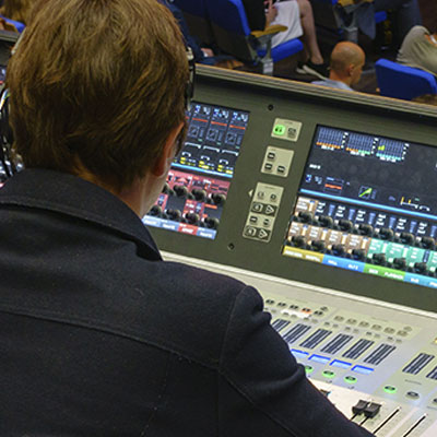  high-tech production environments featuring professional video and audio equipment, showcasing a technician managing a live event.