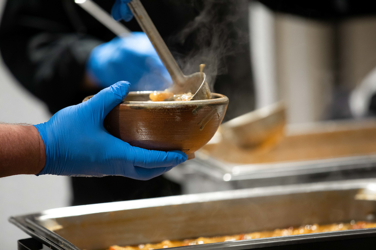 close up of soup bowl in server's hand