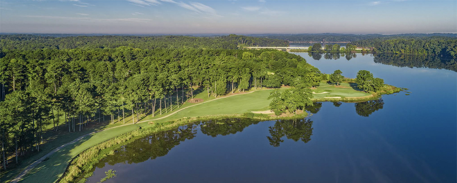 an overhead view of a golf course and lake