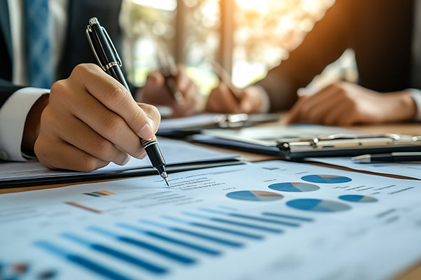 pen on financial documents on desk