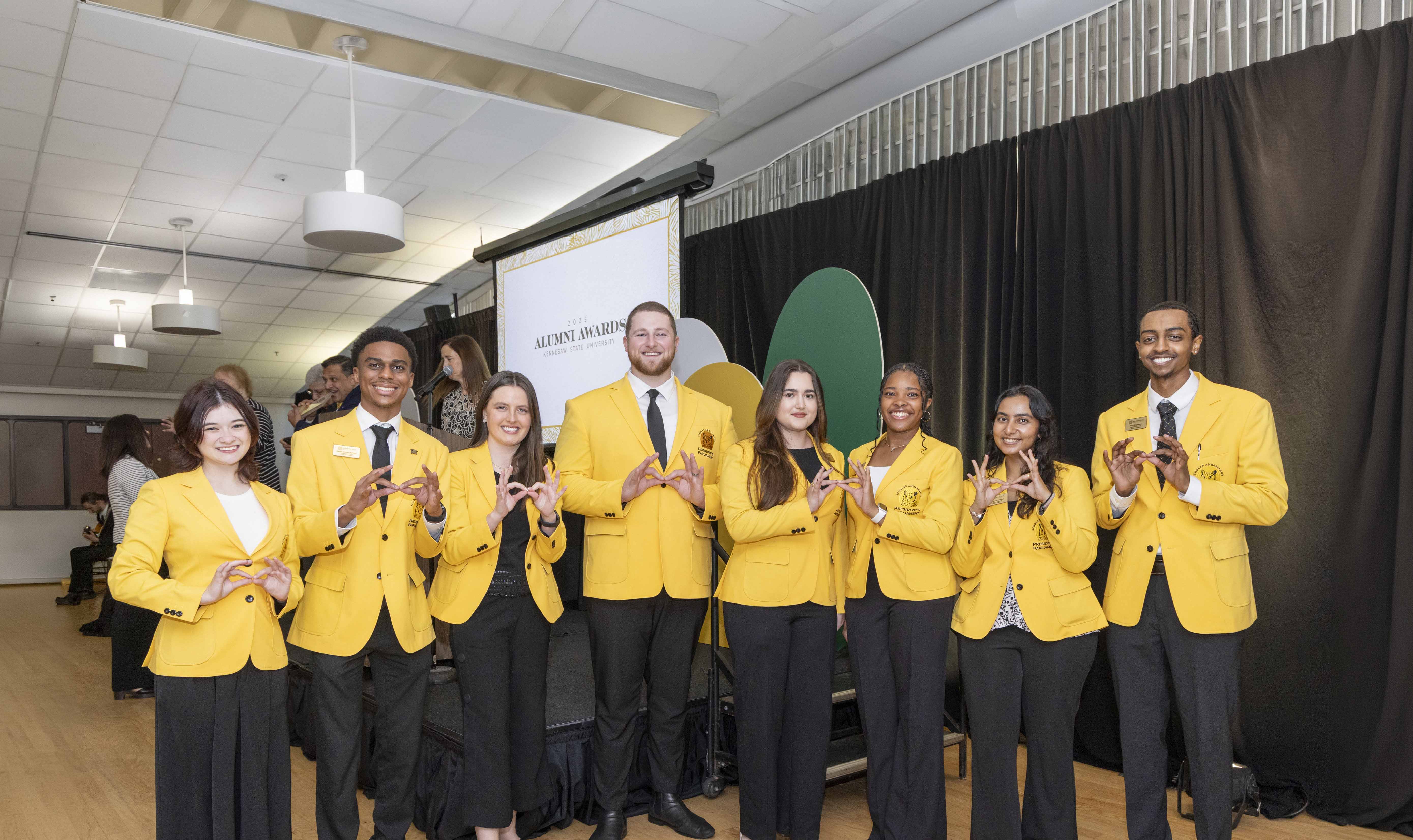 ksu studentrs in yellow blazors smiling at alumni awards ceremony