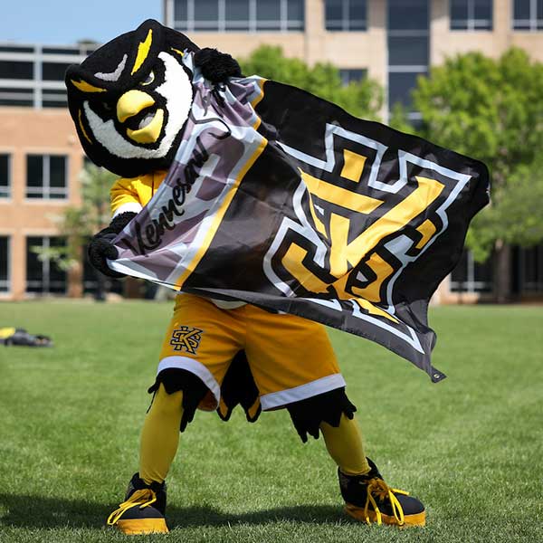 ksu mascot, scrappy, with flag on campus