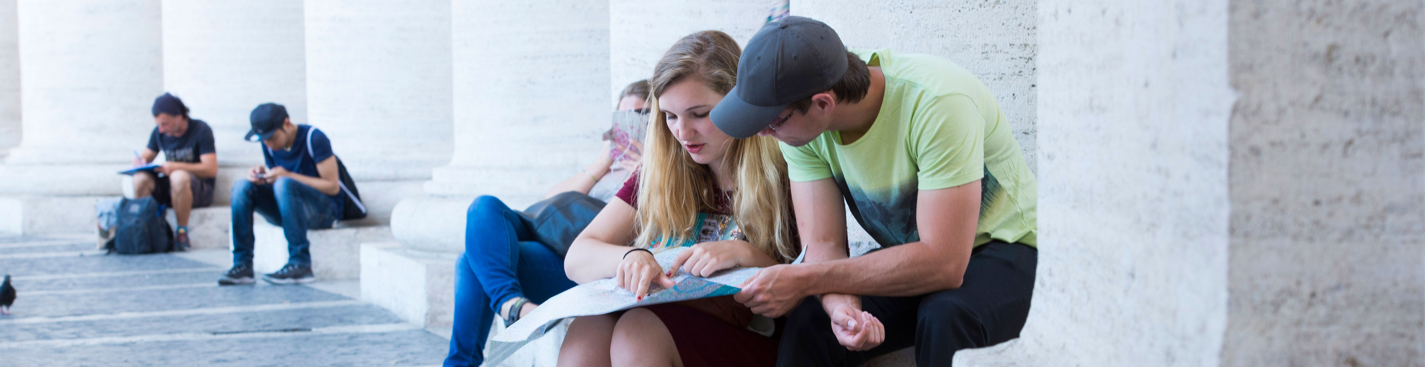 KSU Study Abroad students sitting down looking at a map.