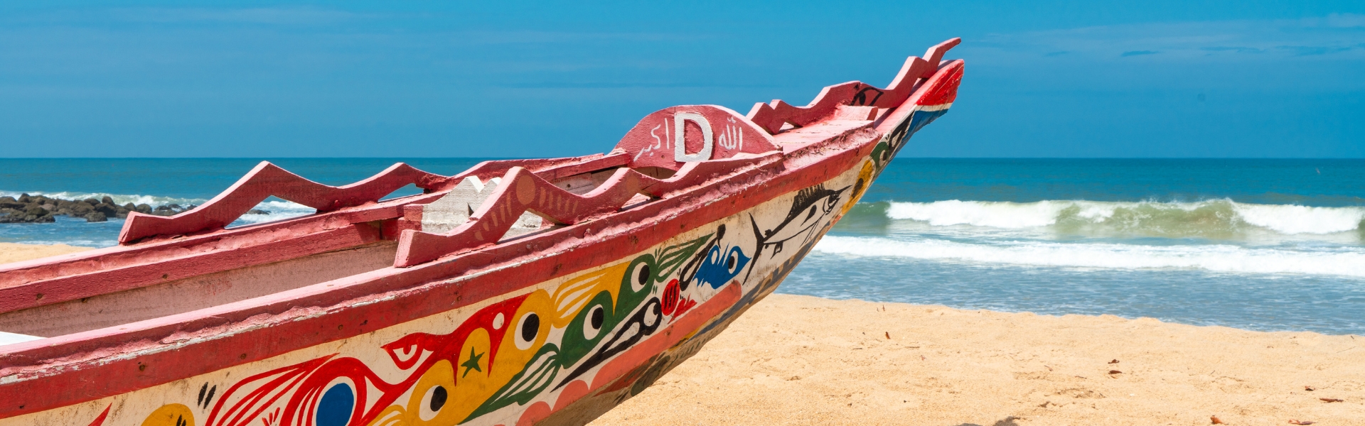 Photo of a boat on the beach sand on the shore in Senegal.