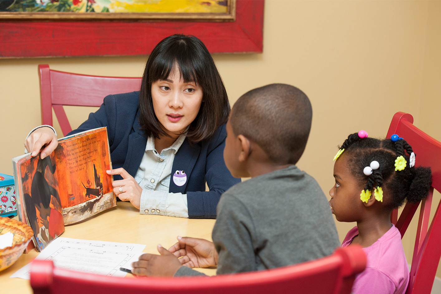 Female teacher reading book to student