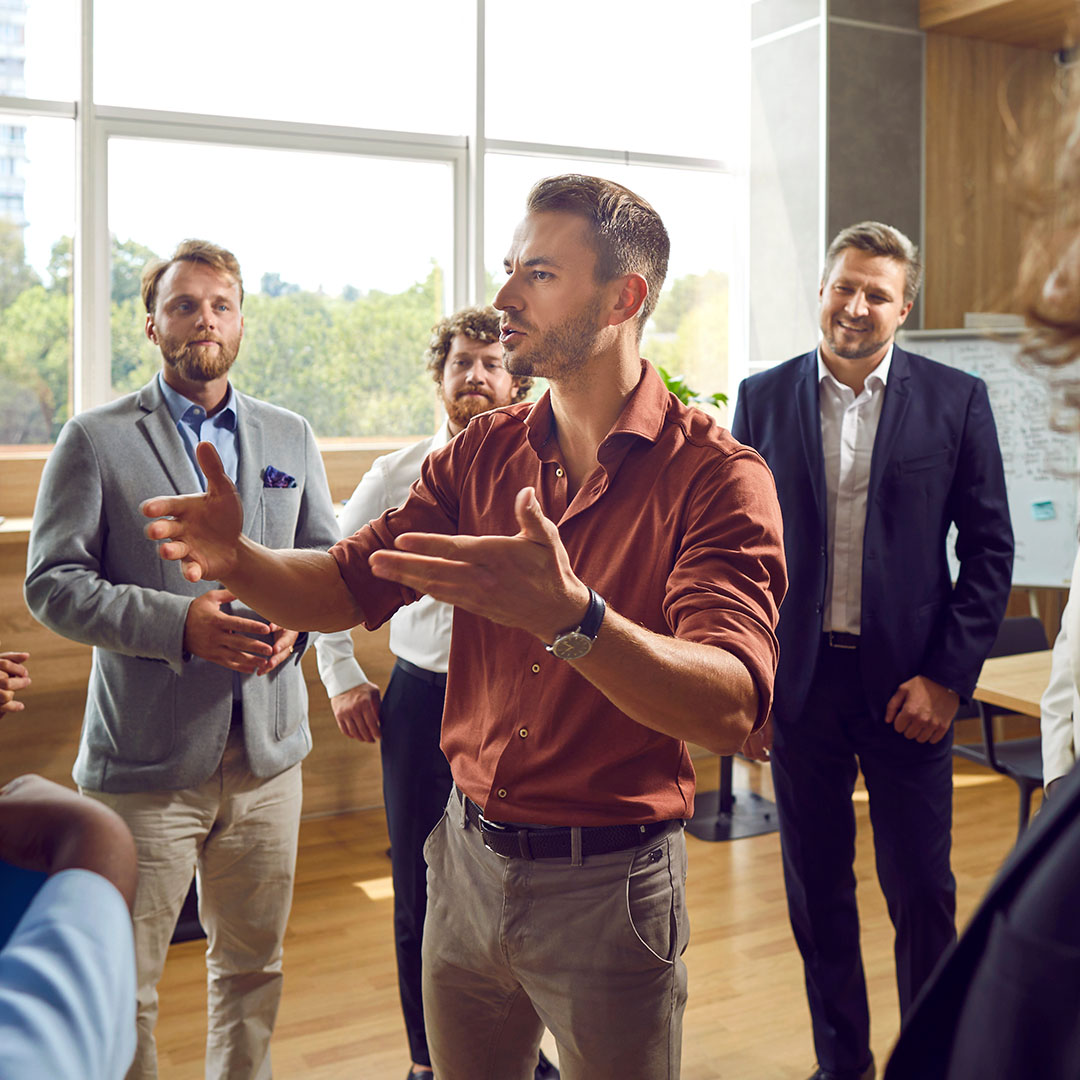 A professional leads a small group discussion during a collaborative workplace meeting.