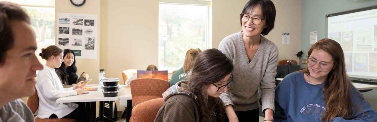 A teacher assists students in a classroom setting