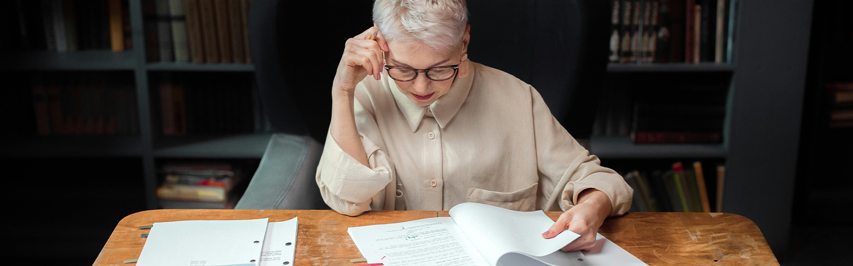 journalist reading papers on a wooden desk studying