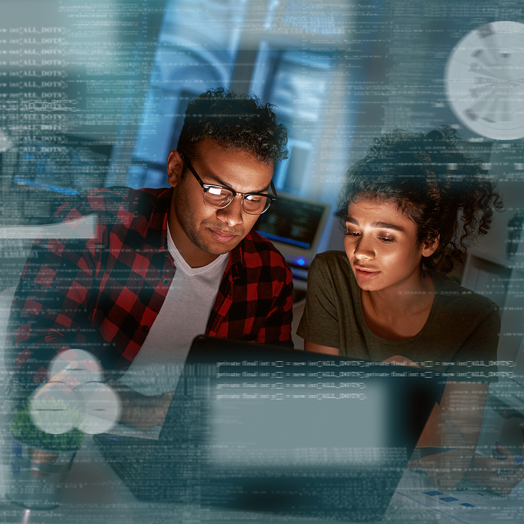 A man and a woman are collaborating while looking at a laptop screen.