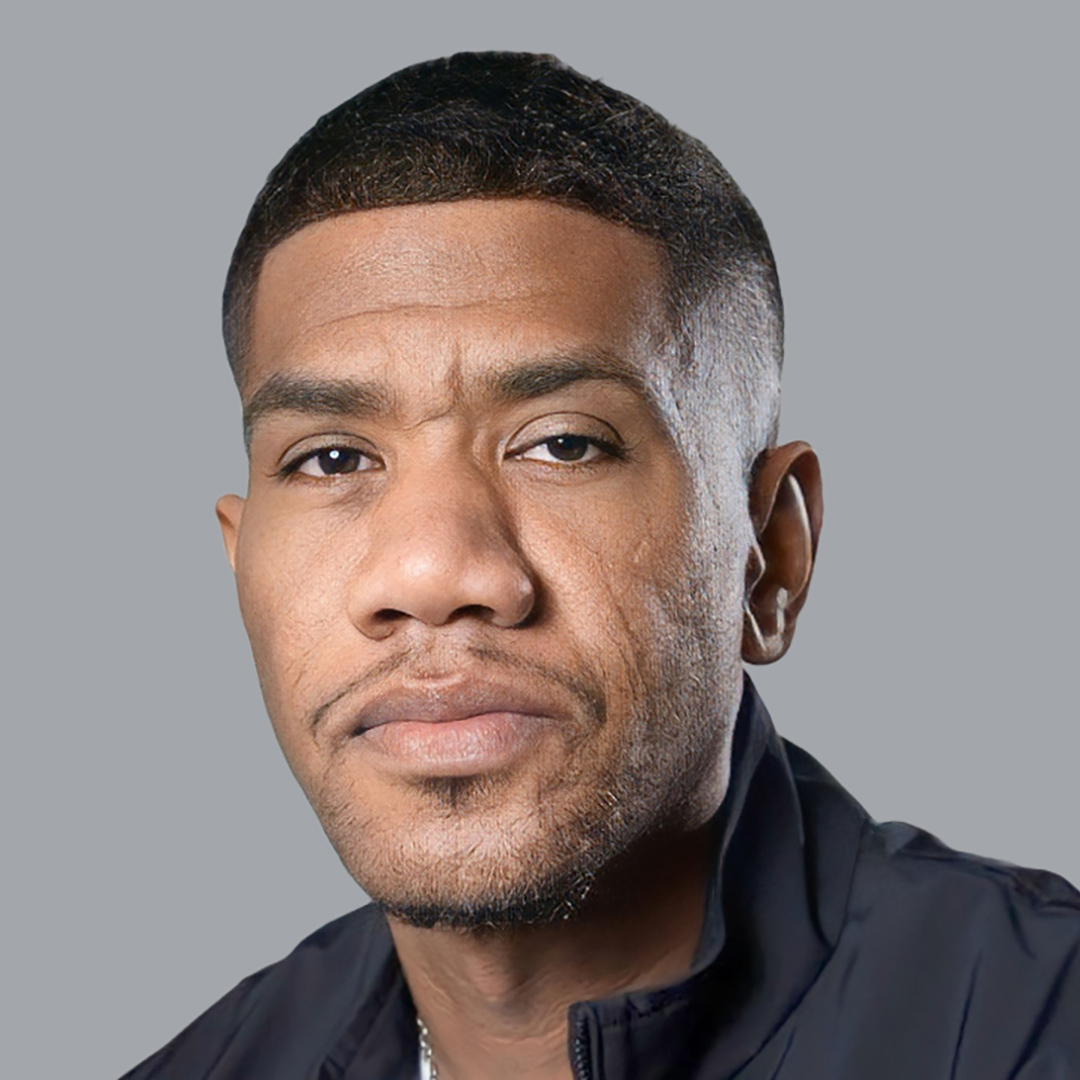 A man dressed in a black jacket, looking relaxed and casual.