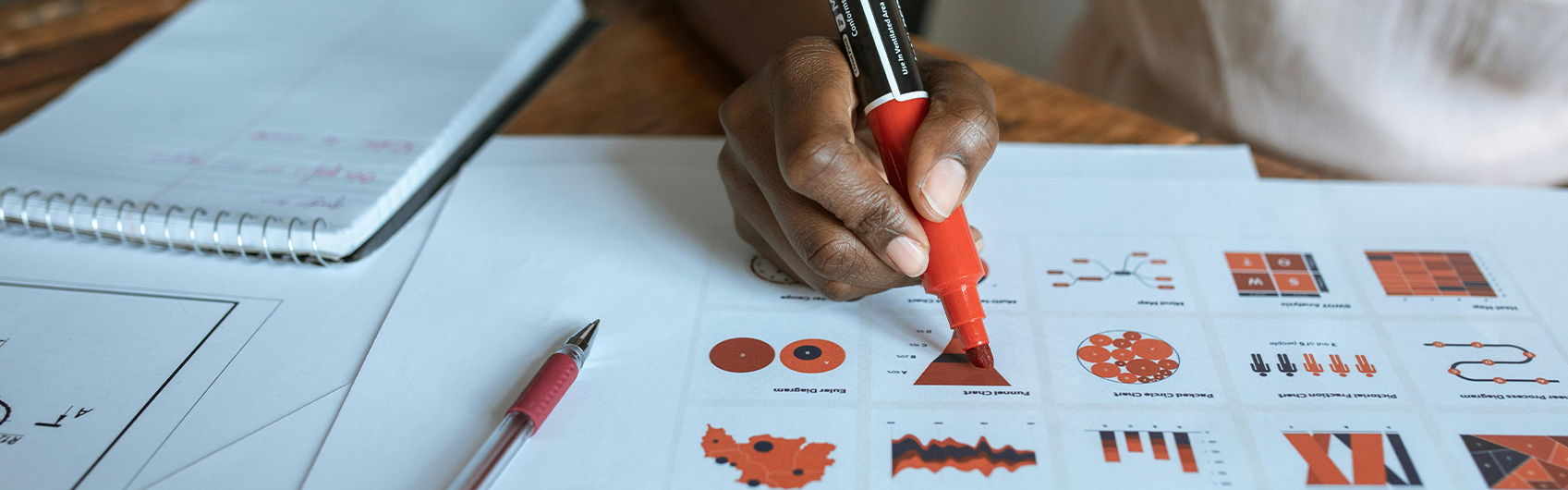 data scientist writing on graph chart in red sharpie marker