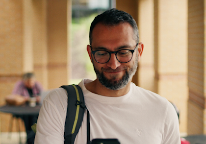 male smiling and looking at her phone