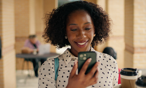 african american female smiling and looking at her phone
