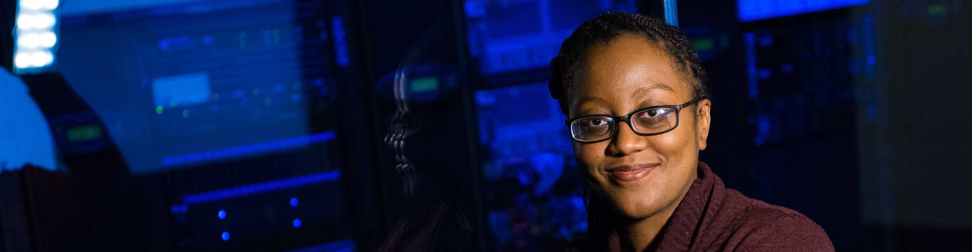 female with glasses smiling in computer room