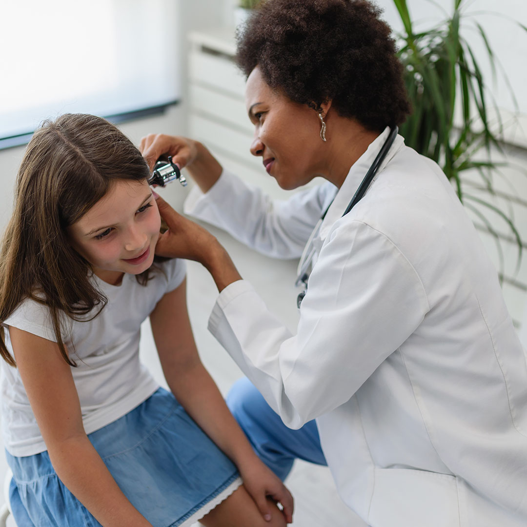 Healthcare provider using a tablet to review information with a patient during a primary care visit.